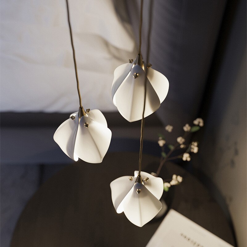 Three white petal-shaped pendant shades